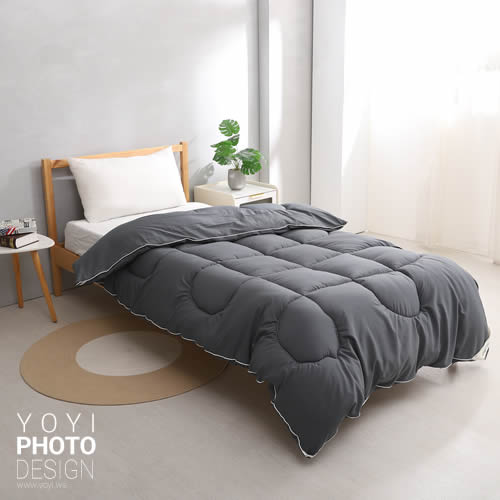 高品質寢具商品攝影作品，展示深灰色棉被與白色滾邊設計。畫面呈現日系簡約風格，營造出溫馨舒適的睡眠氛圍。